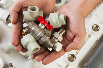 hand_holding_plumbing_parts_and_fixtures.png