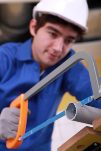 plumber_cutting_pvc_pipe_with_saw.png